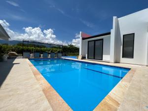a swimming pool in front of a house at PALO ALTO - EXCLUSIVA CASA DE CAMPO in Restrepo