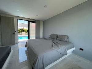 a white bedroom with a bed and a swimming pool at PALO ALTO - EXCLUSIVA CASA DE CAMPO in Restrepo