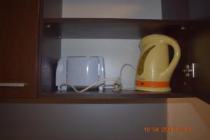 a yellow jug sitting on a shelf next to a appliance at Villa Park Guest Apartments in Borovets