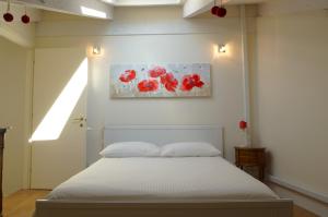 um quarto com uma cama e um quadro de flores vermelhas em Casa Pisterna em Acqui Terme