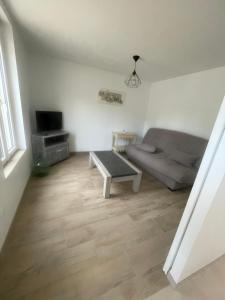 a living room with a couch and a coffee table at Maison de campagne "Le GAULT" in Chartrené