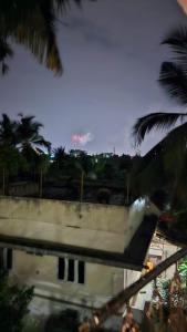 a view of a building with palm trees at Royal Square Service Apartment in Thrissur Town in Trichūr