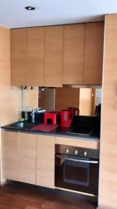 a kitchen with wooden cabinets and a stove top oven at Providencia Studio Suite con Terraza in Santiago