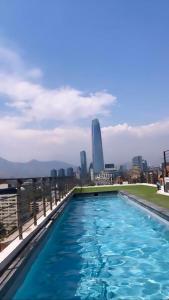 a swimming pool on top of a building with a city skyline at Providencia Studio Suite con Terraza in Santiago