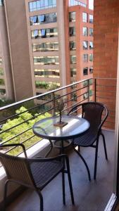 a glass table and two chairs on a balcony at Providencia Studio Suite con Terraza in Santiago