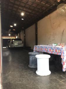 a parking garage with a table and two trash cans at Pendotiba Hostel in São Gonçalo +8 photos