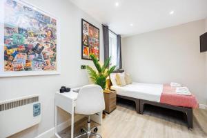 a bedroom with a bed and a desk and a chair at Trendy Rooms Spitalfields in London