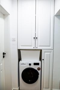 een wasmachine en droger in een keuken met een witte kast bij Clover Apartament in Cluj-Napoca