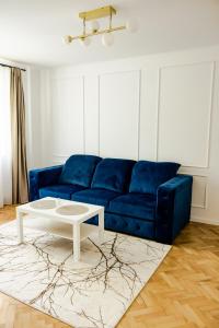 een woonkamer met een blauwe bank en een salontafel bij Clover Apartament in Cluj-Napoca