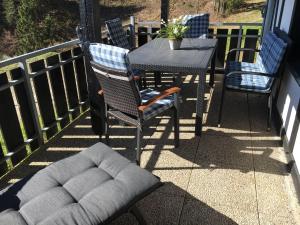 einen Tisch und Stühle auf einem Balkon mit einem Tisch und einem Stuhl in der Unterkunft Landhaus Postwiese in Winterberg