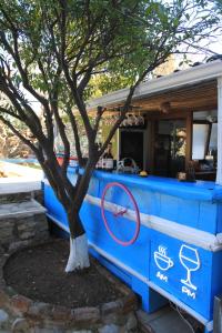 a blue bar with a bike on it next to a tree at Eski Datça Pansiyon in Datca