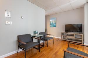 a living room with a table and chairs and a television at Central 3 Bed 1 Bath in Historic Building in Boston