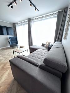 a living room with a couch and a chair at Forest Hill domki - Międzyzdroje -KLIMATYZACJA in Międzyzdroje