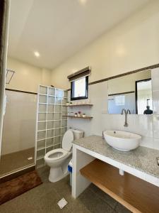 a bathroom with a sink and a toilet and a tub at LB Pietz Pension House in Cordova