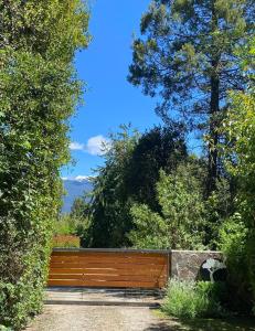 a wooden fence in a garden with trees at Altos del Sur Cabañas de Montaña in El Bolsón +94 photos