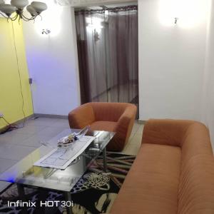 ein Wohnzimmer mit einem Sofa und einem Glastisch in der Unterkunft Belle vue in Douala