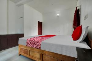 um quarto com uma cama com almofadas vermelhas em Munnar Rest & Lodging em Munnar