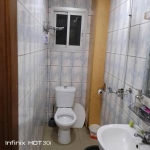 ein Bad mit einem WC, einem Waschbecken und einem Fenster in der Unterkunft Belle vue in Douala
