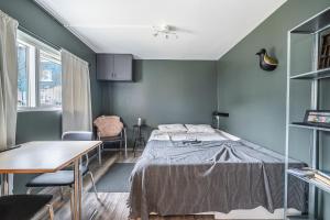 a bedroom with a bed and a table and chairs at Charming cottage in downtown Reykjavik - Birta Rentals in Reykjavík
