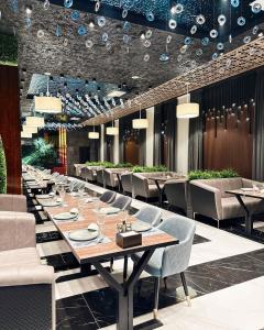 a dining room with a long table and chairs at Marmaris Hotel in Nukus