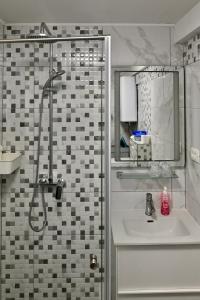 bagno con doccia, lavandino e specchio di Studio Apartman UNA -self check in,free parking a Karlovac