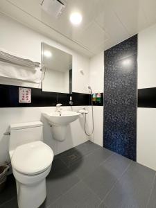 a bathroom with a white toilet and a sink at Ai Lai Fashion Hotel in Taichung