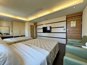 a hotel room with two beds and a television at Ai Lai Fashion Hotel in Taichung