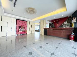 a large lobby with a pink wall and a counter at Ai Lai Fashion Hotel in Taichung