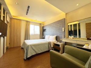 a hotel room with a bed and a couch at Ai Lai Fashion Hotel in Taichung