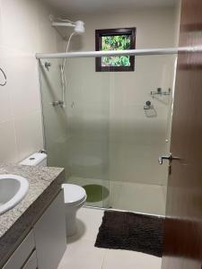 y baño con ducha, aseo y lavamanos. en Apartamento Villas do Pratagy, en Maceió
