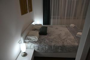 un letto in una camera con una lampada su un tavolo di Studio Apartman UNA -self check in,free parking a Karlovac
