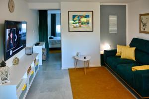 un soggiorno con divano verde e tavolo di Studio Apartman UNA -self check in,free parking a Karlovac