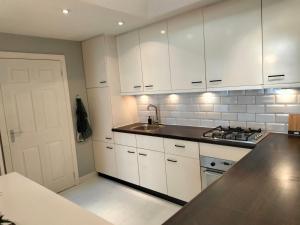 a kitchen with white cabinets and a sink at Family house Scheveningen beach in Scheveningen