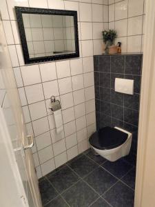 a bathroom with a black and white toilet and a mirror at Family house Scheveningen beach in Scheveningen