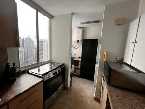 a kitchen with a stove and a large window at Acogedor apartamento en El Cangrejo in Panama City