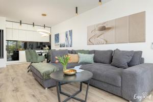 a living room with a gray couch and a table at Perfekt SPA creamy 5 in Dziwnów