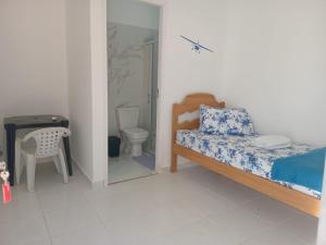 a bedroom with a bed and a toilet and a mirror at POUSADA DAS NAÇÕES lll in Indaiatuba