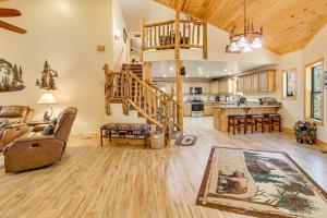 a living room with a staircase and a kitchen at Rustic Lakeside Cabin on 3 Acres w/ Nature Views! in Pinetop-Lakeside