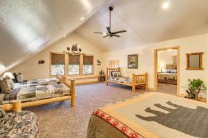a living room with two beds and a ceiling fan at Rustic Lakeside Cabin on 3 Acres w/ Nature Views! in Pinetop-Lakeside