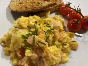 a plate of scrambled eggs with tomatoes and toast at Goodwin House in Keswick