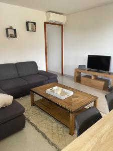 a living room with a couch and a coffee table at Charme provençal près de Nice in Blausasc