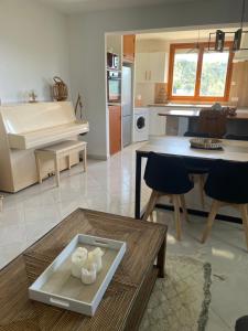 a kitchen and living room with a table and a piano at Charme provençal près de Nice in Blausasc