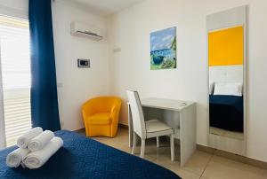 a room with a bed with a desk and a chair at Riviera Ionica in Santa Teresa di Riva