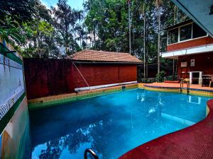 a swimming pool in front of a house at The Twin Cottages in Madikeri