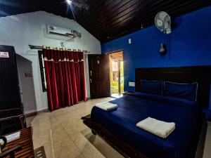 1 dormitorio con 1 cama en una habitación azul en The Twin Cottages, en Madikeri