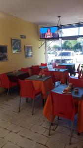 un ristorante con tavoli e sedie e una TV a parete di Hotel Nuevo Real a Formosa