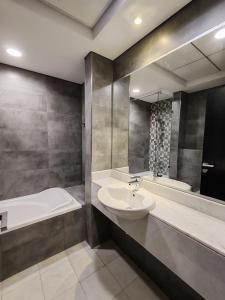 Oval Tower Loft Accommodation في دبي: حمام مع حوض وحوض استحمام ومغسلة