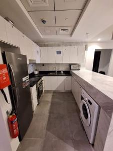 杜拜的住宿－Oval Tower Loft Accommodation，厨房配有不锈钢冰箱和洗碗机