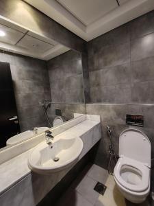 杜拜的住宿－Oval Tower Loft Accommodation，一间带水槽、卫生间和镜子的浴室
