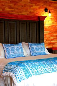 ein Bett mit blauen und weißen Kissen darauf in der Unterkunft Hotel Casa Xaa in Tlatlauquitepec